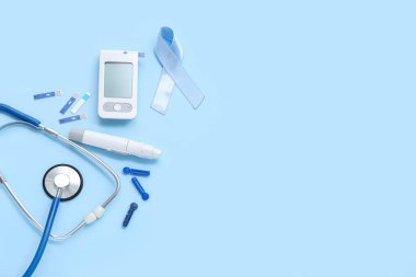 Mavi arka planda glukometresi, lancet kalemi ve steteskobu olan farkındalık kurdelesi. Diyabet kavramı