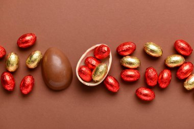 Kahverengi arka planda çikolatalı Paskalya yumurtası ve şekeri.