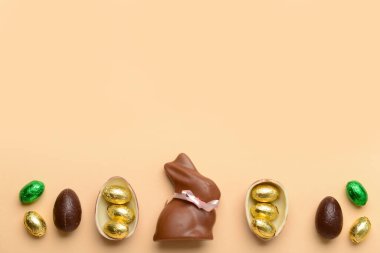Bej arka planda çikolatalı tavşan ve Paskalya yumurtası.