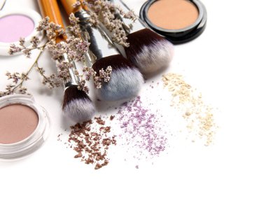 Göz falı makyaj fırçaları ve beyaz arka planda çiçekler, yakın plan