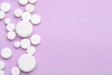 Eflatun arka planda beyaz haplar