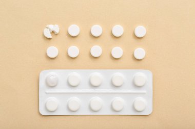 Bej arka planda beyaz haplarla su toplamış.