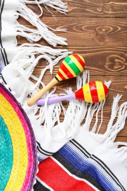 Tahta arka planda seraplı Meksika marakaları.