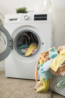Çamaşır odasında kirli çamaşırlar ve çamaşır makinesi olan sepet.