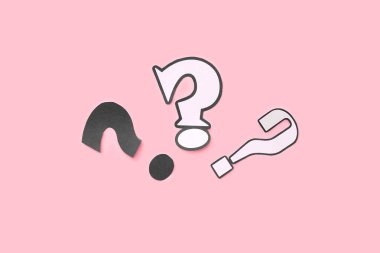 Pembe arka planda kağıt soru işaretleri