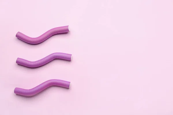 stock image Hair curlers on pink background