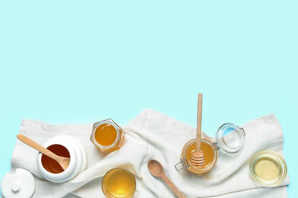 Stock image Jars and bowls with sweet honey on blue background