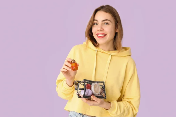 Junge Frau Mit Transparenter Kosmetiktasche Auf Fliederfarbenem Hintergrund — Stockfoto