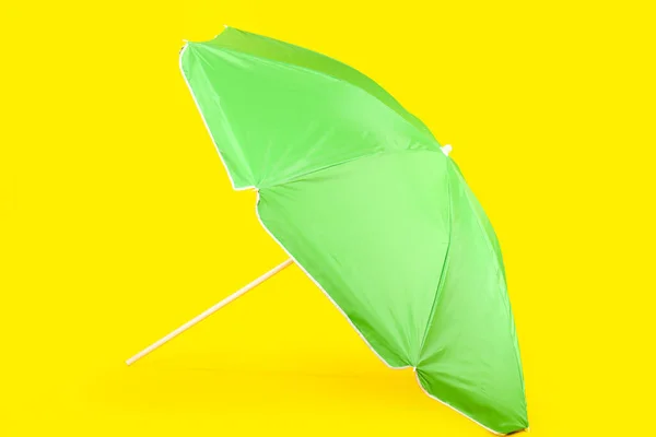 黄色の背景に緑のビーチ傘 — ストック写真
