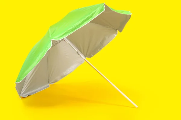 黄色背景的绿色海滩伞 — 图库照片