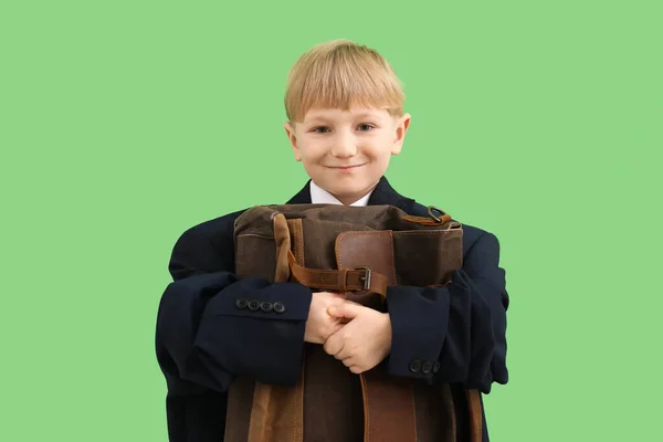 緑の背景にブリーフケース付きの大きなジャケットで面白い小さなビジネスマン — ストック写真