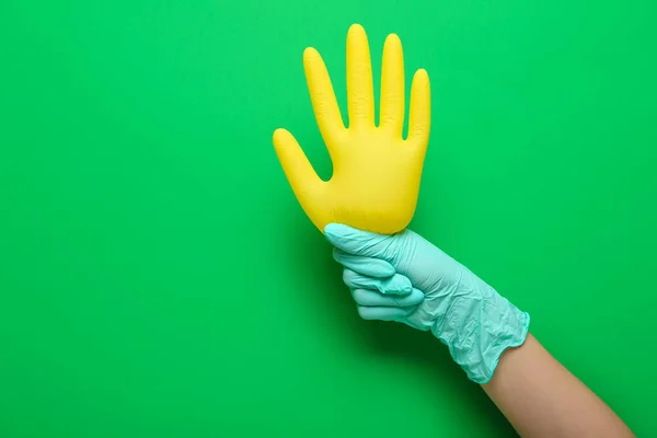 Woman with medical gloves on green background