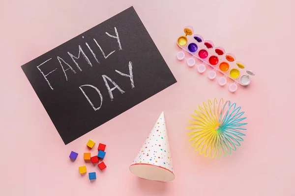 テキスト付きの黒板家族の日 ピンクの背景に子供のおもちゃやパーティーの帽子 — ストック写真