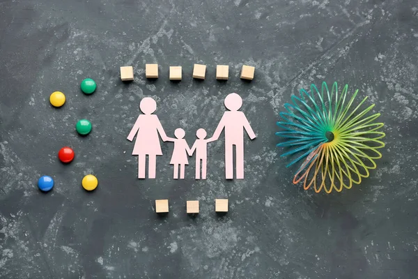 Text FAMILY DAY with paper figure and toys on dark background