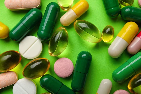 Különböző Tabletták Zöld Háttér Közelkép — Stock Fotó
