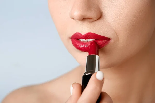 灰色の背景に赤い口紅を適用する女性 クローズアップ — ストック写真