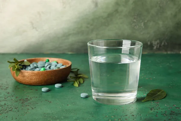 Bowl Pills Leaves Glass Water Green Table Closeup — Stock Photo, Image