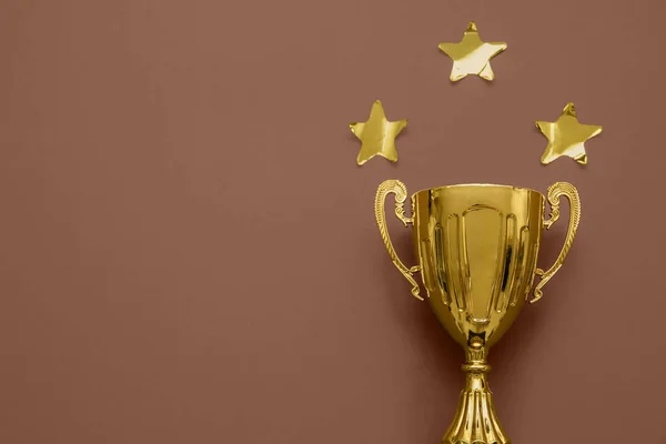 Gold cup with stars on brown background