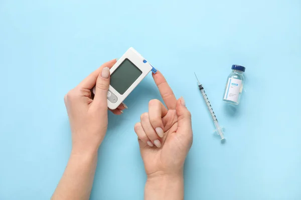 Mujer Usando Glucosímetro Sobre Fondo Azul Concepto Diabetes —  Fotos de Stock