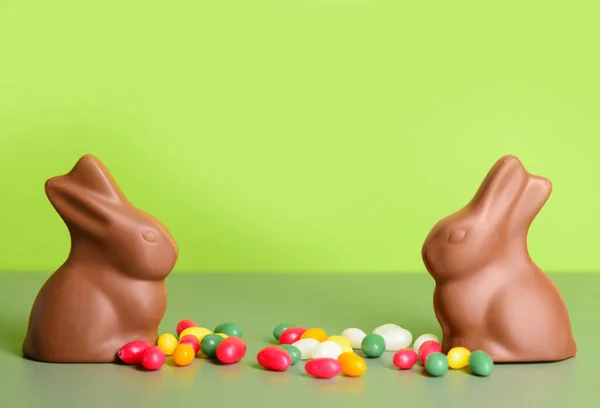 緑の背景にチョコレートイースターバニーとキャンディー — ストック写真