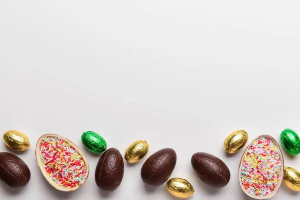 白い背景に甘いチョコレートイースターエッグとキャンディー — ストック写真