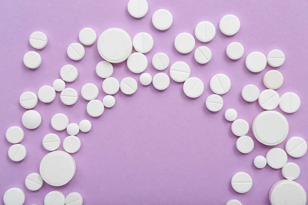 ライラックの背景に白い錠剤で作られたフレーム — ストック写真