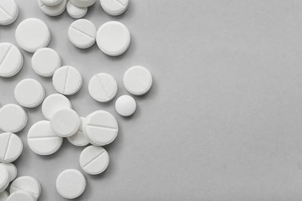 stock image White pills on grey background