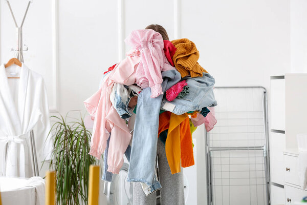 Woman with dirty clothes in laundry room