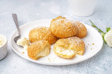 Hafif arka planda lezzetli choux tatlılı tabak.