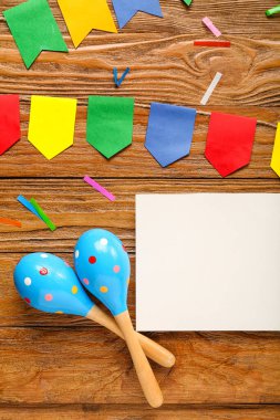 Meksika marakası, bayraklar ve tahta arka planda konfeti olan boş bir kart.