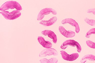 Lipstick kiss marks on pink background