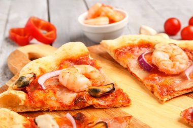 Hafif ahşap arka planda lezzetli deniz ürünleri pizzası, yakın plan.