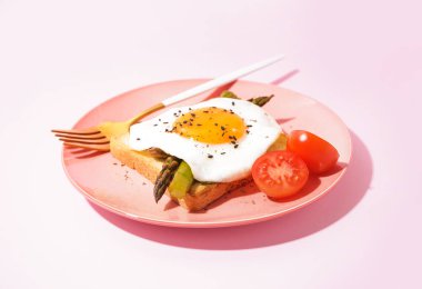 Kızarmış yumurta, kuşkonmaz ve domatesli nefis bir sandviç.