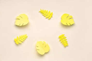 Bej arkaplanda tropikal yapraklardan yapılmış çerçeve