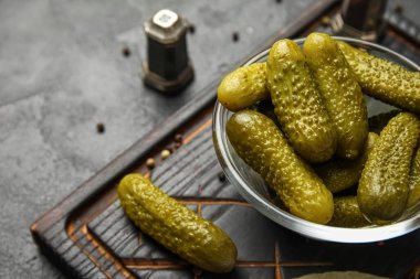 Lezzetli mayalanmış salatalıklı kase koyu grunge arka planda