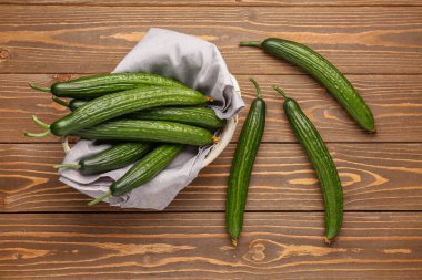 Tahta arka planda taze salatalıklı sepet.