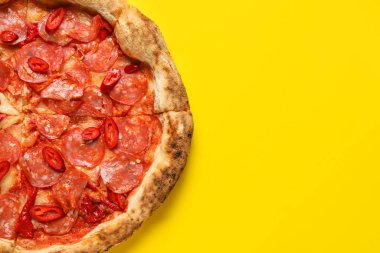 Sarı arka planda nefis pepperoni pizza.