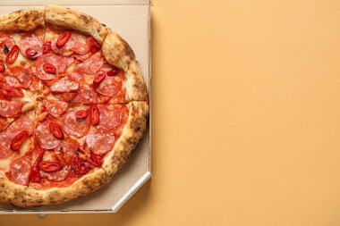 Portakal arkaplanda lezzetli pepperonili pizza olan karton kutu.