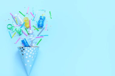 Mavi arka planda konfeti ve yılan balıklı parti konisi. Çocuk Bayramı kutlaması