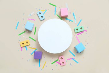 İçinde bebek blokları ve bej arka planda konfeti olan boş bir kart. Çocuk Bayramı kutlaması