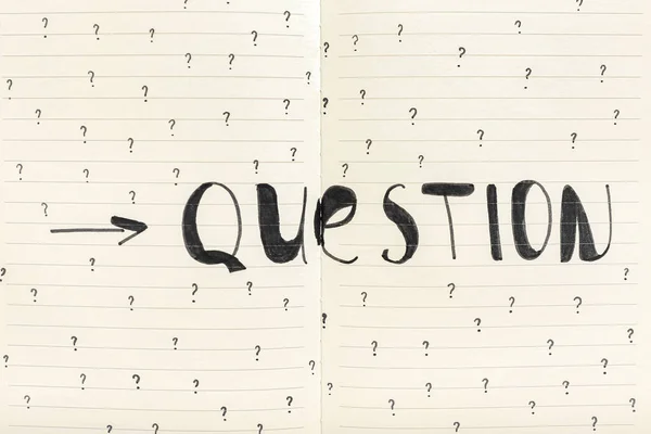 Word QUESTION with drawn marks on notebook, closeup