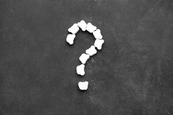 Question mark made of marshmallows on dark background