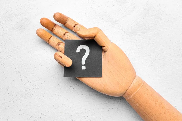 白い背景に紙の質問マークを持つ木製の手 — ストック写真