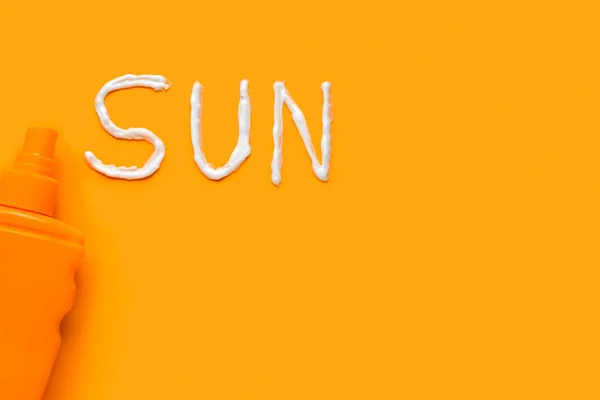 用橙色背景的防晒霜做的单词Sun — 图库照片