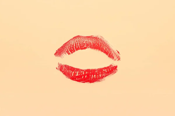 Red lipstick kiss mark on beige background