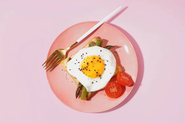 揚げ卵とおいしいサンドイッチ ピンクの背景にアスパラガスとトマト — ストック写真