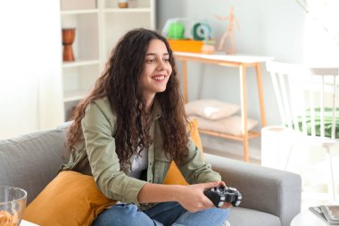 Evde video oyunu oynayan genç bir kız.