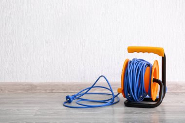 Elektrik kablosu makarası ışık duvarının yanında.
