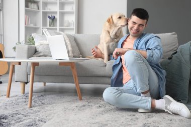 Evinde Labrador köpeği olan genç bir adam.