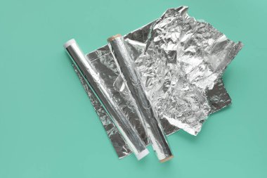 Rolls of aluminium foil on color background